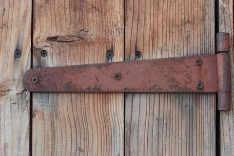 Rusty vintage door hinge on old weathered wooden planks Stock Photos