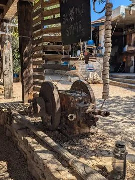 Rusty vintage mechanical engine display in rustic courtyard under sunlight Stock Photos