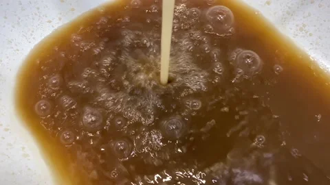 Rusty water flows into the white tub from the tap. Stock Footage 152018502