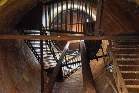 Rusty water tower inside view from top to bottom. Old water pump. Ladder to w Stock Photos