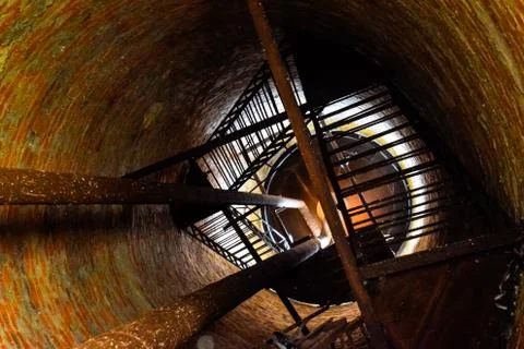 Rusty water tower inside view from top to bottom. Old water pump. Ladder to w Stock Photos