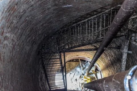 Rusty water tower inside view from top to bottom. Old water pump. Ladder to w Stock Photos