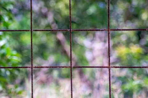 Rusty wire fence with a grid pattern, dividing sections into squares Stock Photos