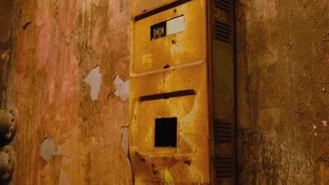 Rusty Yellow Electrical Box on a Cracked and Weathered Wall with Peeling Paint Stock Footage 297389439