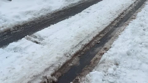 A rut of snow slush on the road in winter during a thaw Stockbeeldmateriaal 317090464