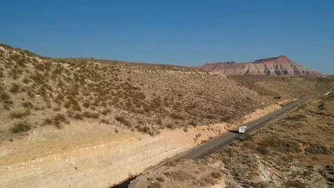 RV driving empty road in middle of nature - drone shot Stock Footage 107879167