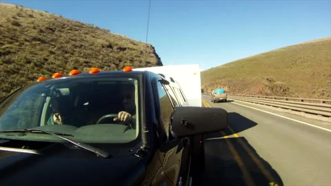 RV driving - pickup truck pulling a Trailer up a hill through sun and shadow Stock Footage 167180699