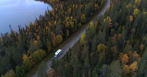 RV on a forest road, Aerial, reverse, drone shot, tilting towards a motorhome Stock Footage 118712326