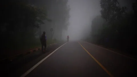 Rwanda - 3 September 2018: a cyclist rides in the fog Stock Footage 138627560