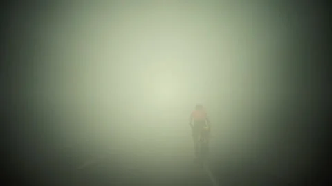 Rwanda - 3 September 2018: a cyclist rides in the fog Stock Footage 138627565