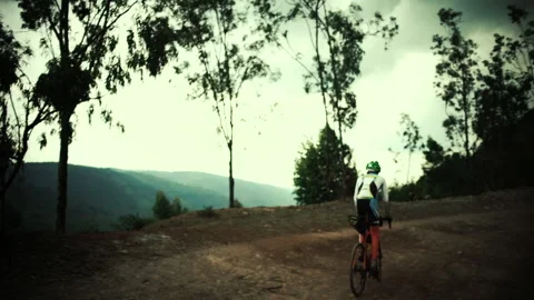 Rwanda - 3 September 2018: cyclists pedal in a dirt climb Stock Footage 138630383