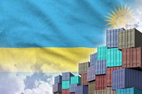 Rwanda flag and big stack of shipping cargo containers in docks with sky Stock Photos