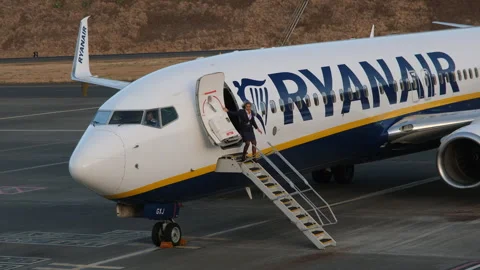 Ryanair flight attendant opens the aircraft door and descends the mobile stairs Видео 345960620