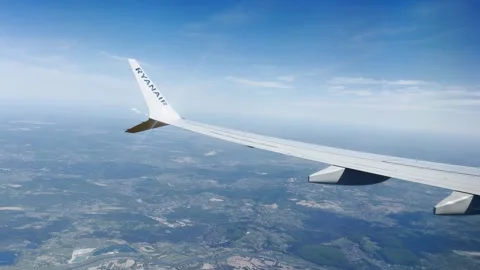 Ryanair wing, airplane window, blue sky, cruising altitude, passenger view Stock Footage 338004038