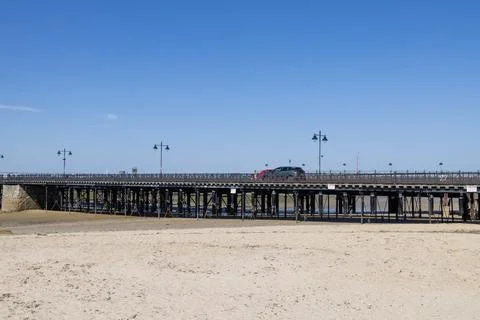 Ryde Pier extending across the sandy shoreline at low tide in Ryde on the I.. 스톡 사진