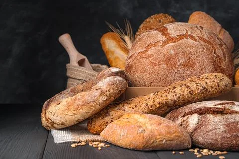 Rye and wheat bread of different types on a dark background. Stock Photos