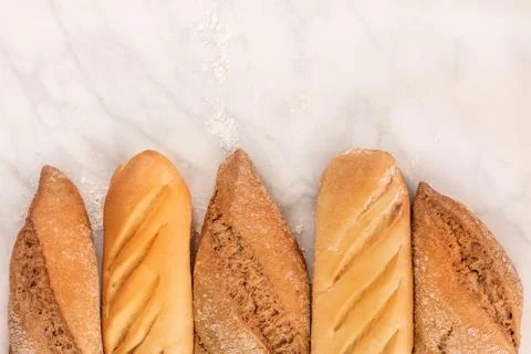 Rye and wheat bread with flour on white marble 写真素材