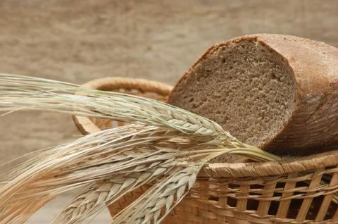 Rye bread and ears of corn in basket Stock-Fotos