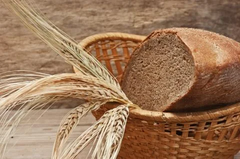 Rye bread and ears of corn in basket 스톡 사진