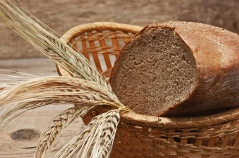 Rye bread and ears of corn in basket 스톡 사진