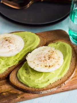 Rye bread avocado toasts with poached egg Stock Photos