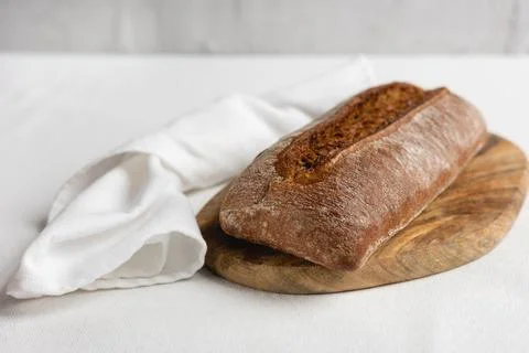 Rye bread on a board on a white tablecloth background Stock Photos