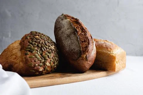 Rye bread on a board on a white tablecloth background Stock Photos