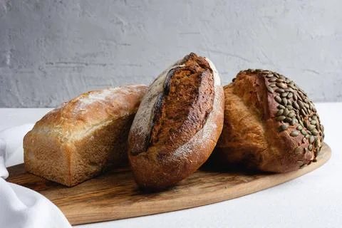 Rye bread on a board on a white tablecloth background Stock Photos