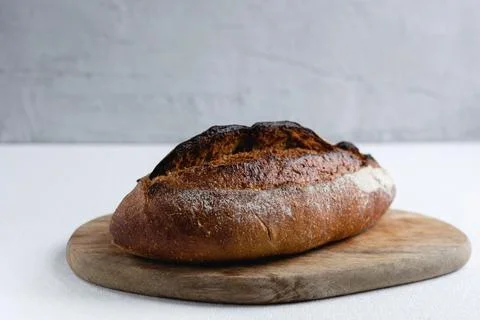 Rye bread on a board on a white tablecloth background Stock Photos