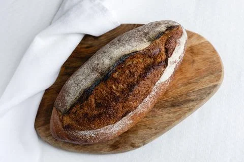 Rye bread on a board on a white tablecloth background Stock Photos