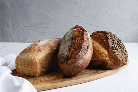 Rye bread on a board on a white tablecloth background Stock Photos