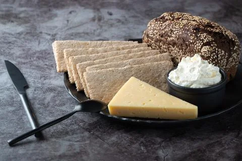 Rye bread, crispbread, cheese, curd cheese in a plate on the kitchen table Stock Photos