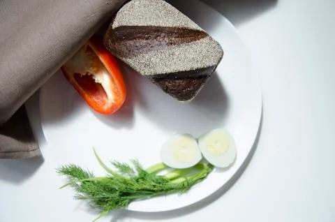 Rye bread, egg and pepper on a white background Stock Photos