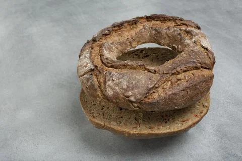 Rye bread in the form of a roll lies on a gray table. rustic style Stock Photos
