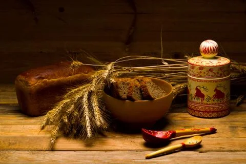 Rye bread, a loaf, ears of corn on a background of wooden boards Stock Photos
