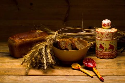 Rye bread, a loaf, ears of corn on a background of wooden boards Stock Photos