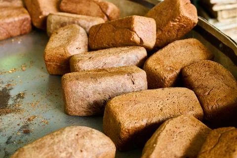 Rye bread loaves cooling on a baking tray in a commercial bakery plant during Stock Photos