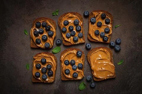 Rye bread with peanut paste and fresh blueberries, top view, no people Stock Photos