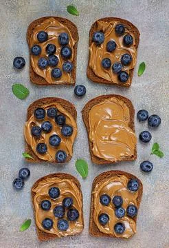 Rye bread with peanut paste and fresh blueberries, top view, no people Stock Photos