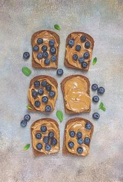 Rye bread with peanut paste and fresh blueberries, top view, no people Stock Photos