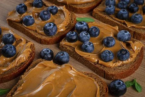 Rye bread with peanut paste and fresh blueberries, top view, no people Foto stock
