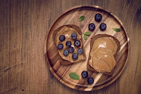 Rye bread with peanut paste and fresh blueberries, top view, no people Stock Photos