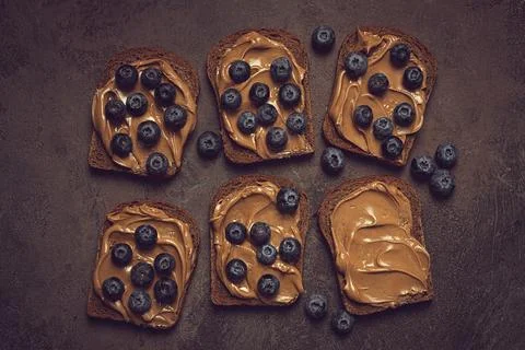 Rye bread with peanut paste and fresh blueberries, top view, no people 스톡 사진