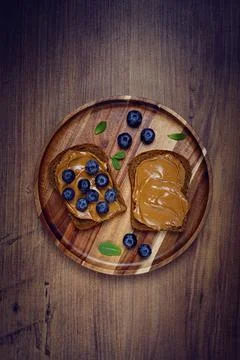 Rye bread with peanut paste and fresh blueberries, top view, no people 스톡 사진