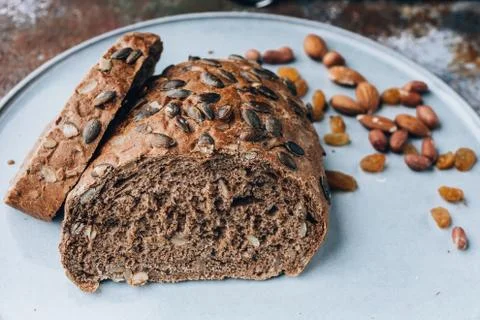 Rye bread with pumpkin seeds and nuts on a large light plate. Stock Photos