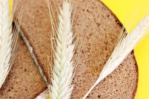 Rye bread, rye ears are located on a yellow background Stock Photos