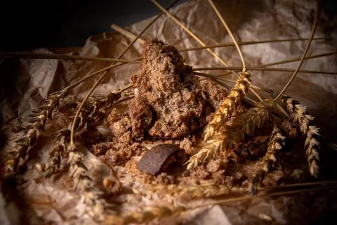 Rye bread with rye spikelets on unfolded parchment paper. Stock Photos