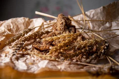 Rye bread with rye spikelets on unfolded parchment paper. Stock Photos