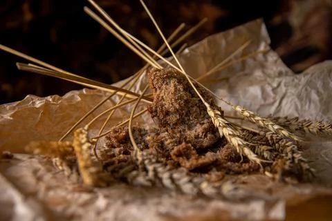 Rye bread with rye spikelets on unfolded parchment paper. Stock Photos
