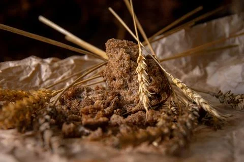 Rye bread with rye spikelets on unfolded parchment paper. Stock Photos